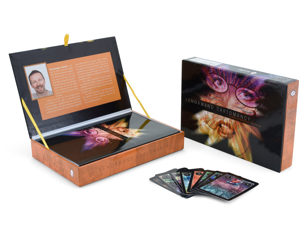 The Lenormand Cartomancy kit by Schiffer Publishing, Ltd. features a colorful guidebook and deck in an open box. Nearby, the closed box displays vivid artwork with several Lenormand fortune telling cards fanned out on a white surface.
