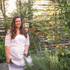 A woman with long brown hair smiles in a lush garden, pruning shears in hand—perfect inspiration for homemade recipes using garden ingredients, as featured in Schiffer Publishing, Ltd.'s Big Book of Botanical Crafts.