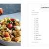 A fork lifts pasta with tomatoes and mozzarella from a bowl on the left; on the right, "The Carlino Family Cookbook" by Schiffer Publishing, Ltd. displays its contents page with sections and page numbers inspired by Carlino family recipes.