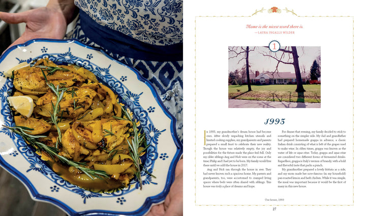 A person in a blue patterned apron holds a platter of roasted chicken with lemon wedges and herbs beside The Carlino Family Cookbook by Schiffer Publishing, Ltd., open to a page with family recipes and a house photo under the story titled 1995.