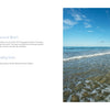 A tropical beach scene—clear blue water, smooth rocks, palm trees left, gentle waves right—featured in "Beaches" by Schiffer Publishing, Ltd.; ideal for fans of beautiful beach photography.