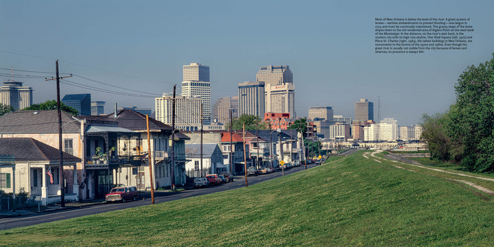 A grassy levee borders homes in the foreground, reminiscent of 1990s New Orleans scenes, with the city's modern skyline rising behind—all as featured in "New Orleans" by Schiffer Publishing, Ltd.