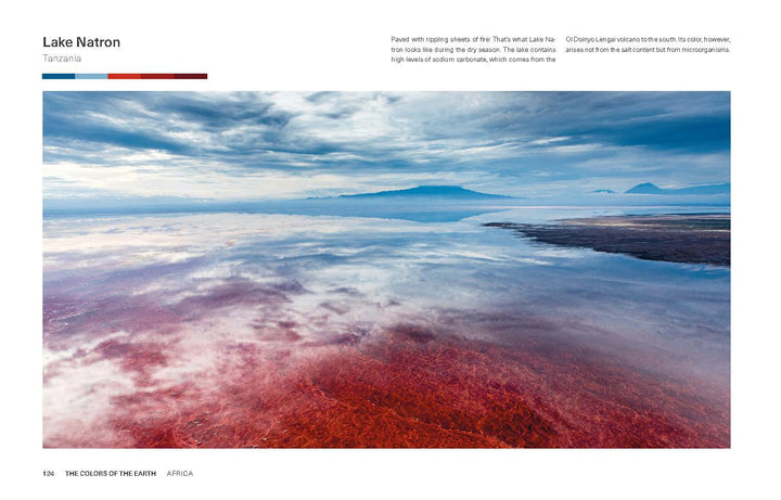 Experience the vivid beauty of Lake Natron, as captured in "The Colors of the Earth" by Schiffer Publishing, Ltd.—red waters, dramatic skies, and reflections of clouds and mountains create a stunning Tanzanian panorama.