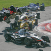 A dramatic moment from Inside Formula 1 by Schiffer Publishing, Ltd.: multiple open-wheel cars crash near red and white curbs, one airborne with debris flying—an intense scene captured in Formula 1 racing photography.