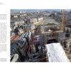Captured in "Restoring Notre-Dame de Paris" by Schiffer Publishing, Ltd., a wide view shows Notre-Dame Cathedral under restoration after the fire, surrounded by scaffolding, cranes, the Seine River, and Parisian buildings on a clear day.