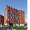 A modern commercial building with a bold rust-colored panel facade and large windows highlights the environmental benefits featured in "Innovations in Mass Timber" by Schiffer Publishing, Ltd., set amid trees, grass, and a welcoming entrance path.