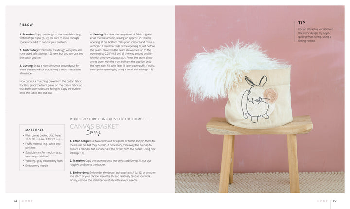 The book "Stitch with One Line" by Schiffer Publishing, Ltd. is displayed on a light wooden surface against a pink wall, accompanied by a canvas bunny basket filled with fluffy white material and embroidery project tips.