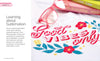 A close-up of a white cloth made with Sublimation Crafting by Schiffer Publishing, Ltd. displays colorful "Good Vibes Only" text with floral designs. Pink-rimmed glasses and vibrant books appear partly in the background.
