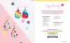 A flat lay displays two pairs of teardrop earrings—one with colorful stripes, one with a pink floral pattern—plus Schiffer Publishing, Ltd.’s Sublimation Crafting instructions and sublimation guide for making “scrap” earrings.