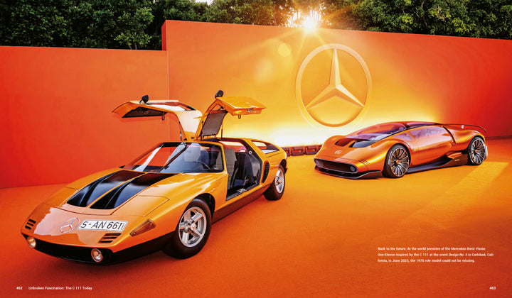 Two orange Mercedes-Benz C 111 models from Schiffer Publishing, Ltd. are displayed on an orange stage—one with its gullwing doors open, the other a sleek, futuristic coupe. The legendary sports car features a Wankel rotary engine.