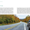A pickup truck adorned with stickers is parked along a scenic route from "Back Roads of the Mid-Atlantic States" by Schiffer Publishing, Ltd., surrounded by vibrant autumn trees and perfect for landscape photography under an overcast sky.