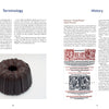 A book spread from "Collectible Cast Iron" by Schiffer Publishing, Ltd. shows left-page text on terminology, a photo of a dark cast-iron Bundt pan with foundry marks; the right page presents history and an old illustrated pan advertisement.
