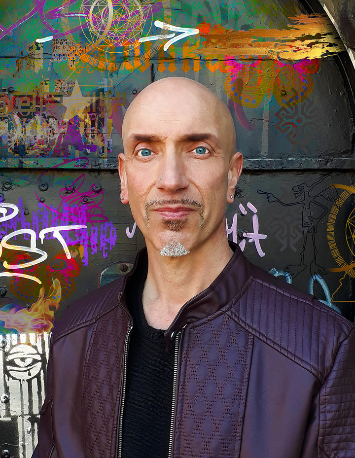 A bald man with blue eyes, a trimmed goatee, and earrings wears a dark brown textured jacket, standing before a vibrant graffiti wall inspired by Schiffer Publishing, Ltd.'s Starman Tarot Remastered.