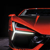 Close-up of the front left side of a red Automobili Lamborghini Special Edition sportscar with angular LED headlights and sharp lines, set against a dark background—a tribute from Schiffer Publishing, Ltd.