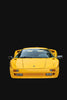 A bright yellow Automobili Lamborghini Special Edition by Schiffer Publishing, Ltd. is shown from the front against a solid black background, featuring a sleek, low design with pop-up headlights and aerodynamic side mirrors.