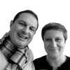 A man in a striped scarf and a woman with short hair smile at the camera against a white background, capturing the playful spirit of 80s design as featured in Schiffer Publishing, Ltd.'s "Iconic Objects of the 1980s.