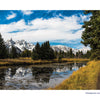 A scenic trail traces a pond framed by pine trees and grass, with snow-capped peaks rising behind—a signature Grand Teton National Park landscape featured in this Schiffer Publishing, Ltd. book, ideal as a souvenir or photography collection.