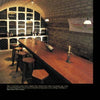 Schiffer Publishing, Ltd.'s Wine Cellar Design blends historic charm and inviting ambiance with an arched stone ceiling, bottle-lined shelves, a wooden table, and warm pendant lights for a rustic yet luxurious look.