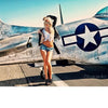 A woman poses in front of a vintage silver airplane, channeling the look from Alvarado's Classic Modern Pin-ups by Schiffer Publishing, Ltd.—a modern take on pin-up style inspired by classic photography.