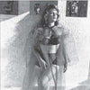 A woman in vintage-style lingerie and a sheer robe poses by a tiled wall with jugs behind her, evoking classic 1950s glamour as seen in "Femmes Fatales of the 1950s" by Schiffer Publishing, Ltd.
