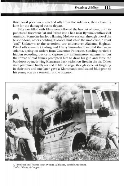 Black and white photo from "Ku Klux Terror" by Schiffer Publishing, Ltd.: A burning bus on its side, smoke rising, people nearby. One person helps a man on the ground—a powerful civil rights era scene in Alabama.