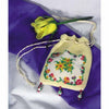 The book "Knitting Beaded Purses" by Schiffer Publishing, Ltd. is displayed on purple and white fabric next to a yellow artificial rose.