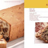 A loaf of fruit-filled bread, inspired by traditional Serbian recipes from "Serbian Cooking" by Schiffer Publishing, Ltd., is sliced on a plate beside a decorative container, while slices are served with coffee and a Kommisbrood recipe.