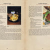 Two pages from "Medieval Cooking in Today's Kitchen" by Schiffer Publishing, Ltd. showcase historical recipes for Anglesey Eggs and Cornish Sausages, each pictured plated with garnishes and classic tableware.