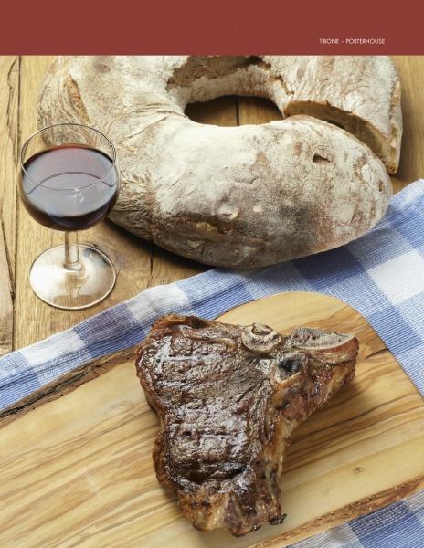 A grilled Pure Steak by Schiffer Publishing, Ltd. sits on a wooden board next to a glass of red wine and rustic bread, all arranged atop a blue and white checkered cloth.
