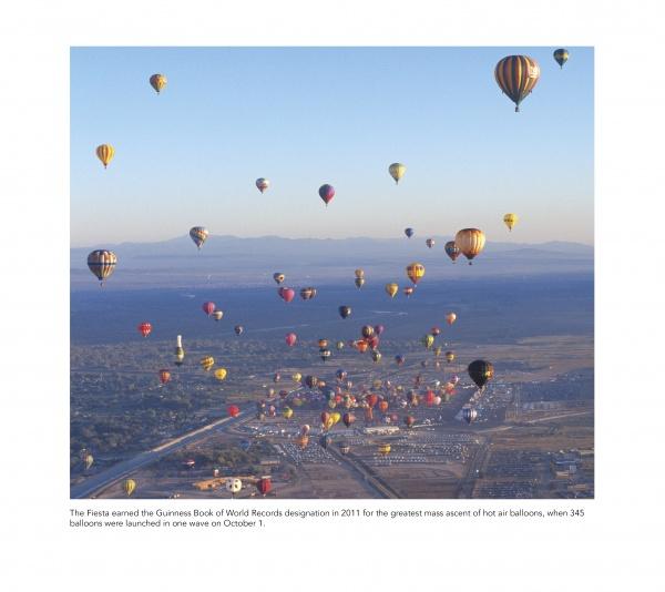 Dozens of colorful hot-air balloons soar above Albuquerque, with mountains and town below, as featured in "Balloons Over Albuquerque" by Schiffer Publishing, Ltd., highlighting the record 2011 Balloon Fiesta launch.