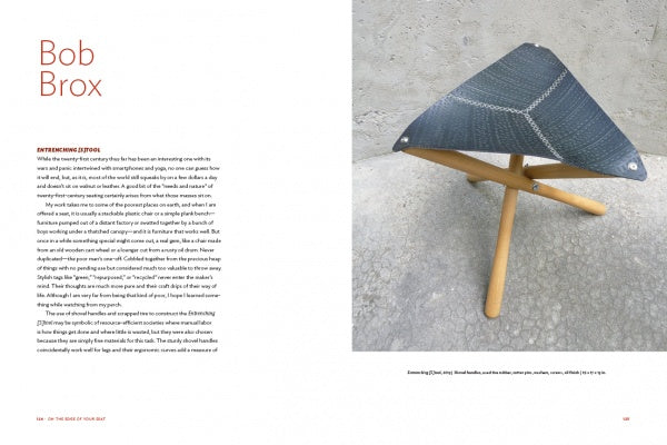 A magazine spread showcases "On the Edge of Your Seat" by Schiffer Publishing, Ltd.: text about designer Bob Brox's influence on American furniture on the left, and a photo of a black triangular stool with wooden legs on a gray stone floor on the right.