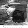 A black and white photo shows a small, stone cave-like structure with a dark entrance, partly covered by grass and soil. This unusual spot is featured on page 78 of "Strange New Hampshire" by Schiffer Publishing, Ltd.