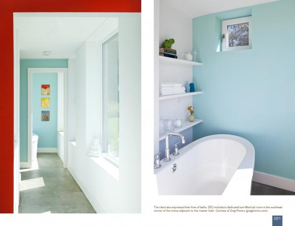 A modern bathroom with blue and white walls, a freestanding tub, and natural light showcases innovative home design as seen in "Contemporary Boston Architects" by Schiffer Publishing, Ltd.
