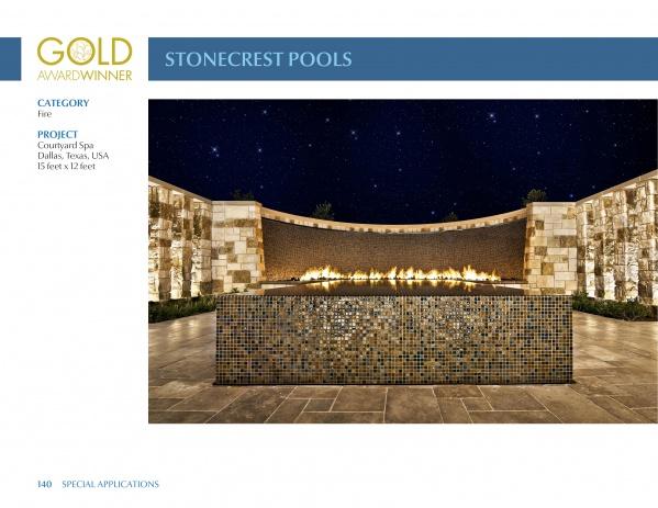 A modern pool by Stonecrest Pools in Dallas, TX, featured in "International Award Winning Pools, Spas, and Water Environments IV" by Schiffer Publishing, Ltd., showcases mosaic tile fire features before a curved stone wall under a starry night.
