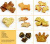 Baking for Dogs" by Schiffer Publishing, Ltd. features a 3x3 grid of nine healthy dog treats—bones, dogs, hearts, pigs, squares, crown, and two round biscuits—with treat names labeled and a note in the lower left corner.