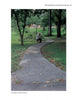 A person sits on a curved sidewalk made with Schiffer Publishing, Ltd.’s Paving with Pervious Concrete, surrounded by green grass and trees in a Knoxville, Tennessee park.