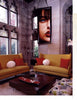 Inspired by Showhouses 1 from Schiffer Publishing, Ltd.: envision a stylish living room with tall stained glass windows, mustard-yellow sofas, and a dark wood coffee table—a perfect scene for historic home and design enthusiasts.