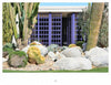 Showcasing the Palm Springs Mid-century Modern style by Schiffer Publishing, Ltd., a modern building with purple grid doors is set among large cacti, agave, rocks, a desert landscape, and green grass in the foreground.