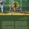 A woman guides her dog through an agility hoop in a grassy, pet-friendly yard, demonstrating ideas from "Petscaping" by Schiffer Publishing, Ltd.—a resource for creating engaging outdoor environments for pets.