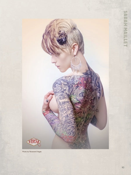 A woman with short blonde hair, hoop earrings, and bold tattoos poses for Ink ’N Girls by Schiffer Publishing, Ltd., showcasing vibrant body art and script tattoos—a striking example of tattooed women.