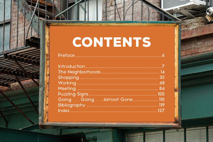 An orange sign outside a NYC brick building, resembling vintage advertising, displays a table of contents—an image featured in "Ghost Signs 2" by Schiffer Publishing, Ltd., inspired by the city’s historic ghost signs.