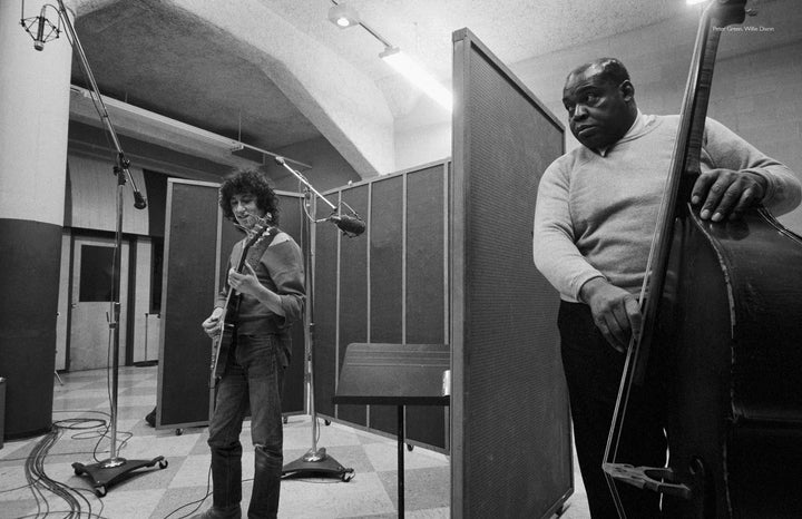 A black-and-white photo evokes a Chess Studios Chicago, 1969 vibe with two musicians—one smiling on electric guitar, the other serious on upright bass—like the "Fleetwood Mac in Chicago" album from Schiffer Publishing, Ltd.