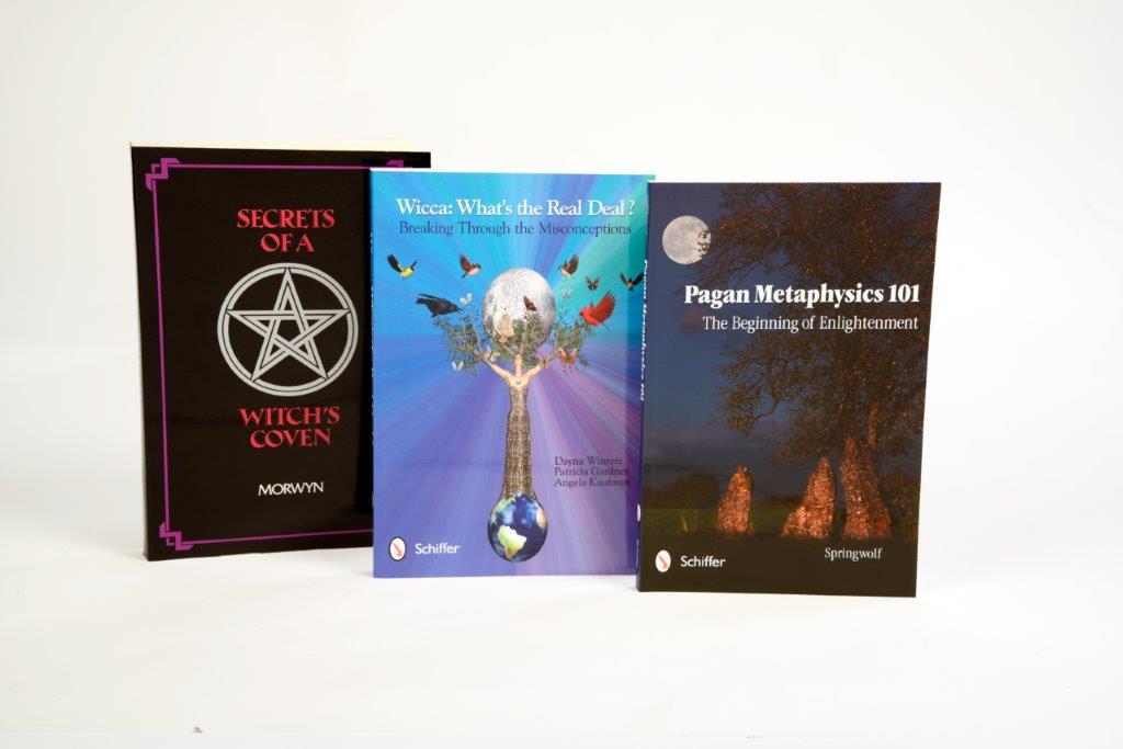 The WICCAN AND PAGAN STARTER PACK FOR ADULTS by Schiffer Publishing features upright books with covers adorned by mystical symbols and enchanting nature-themed artwork.